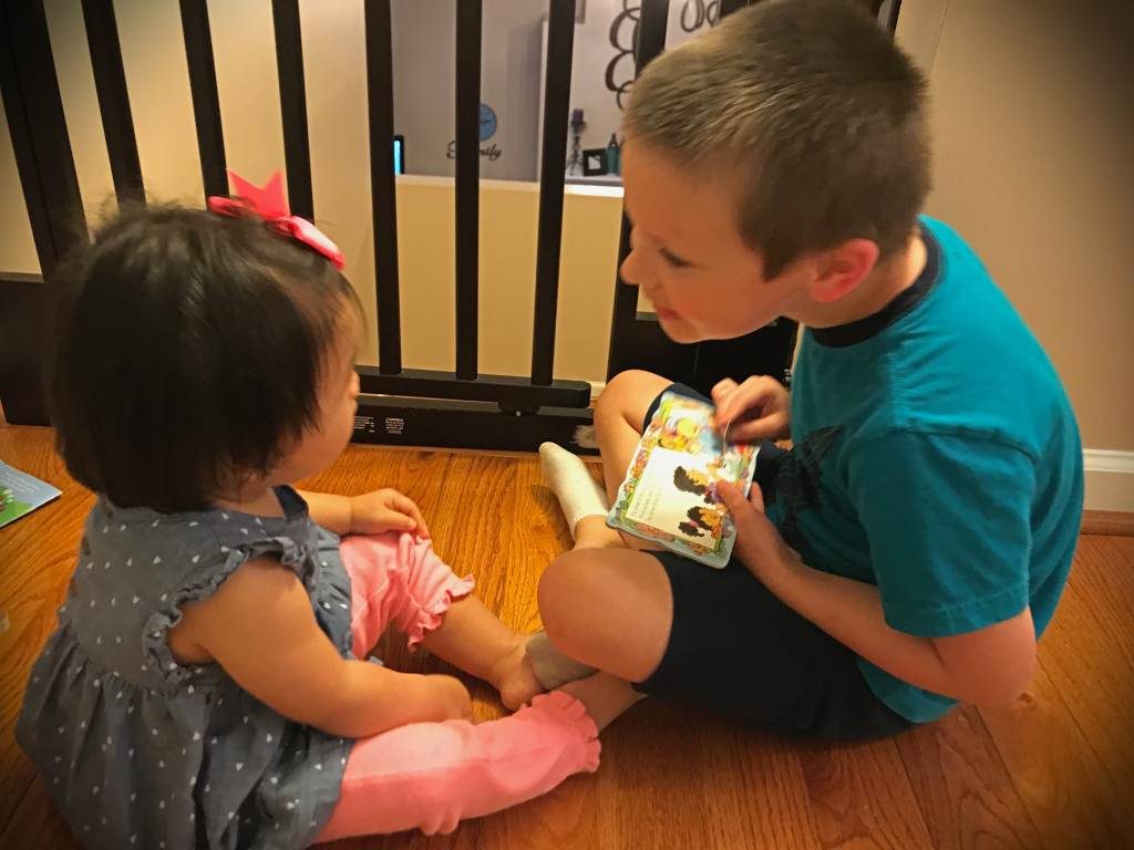 Boy reading to his sister