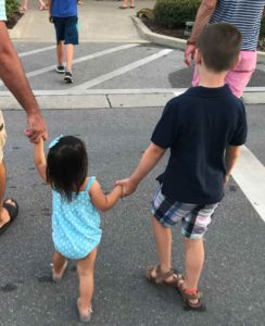 Boy and girl holding hands, siblings