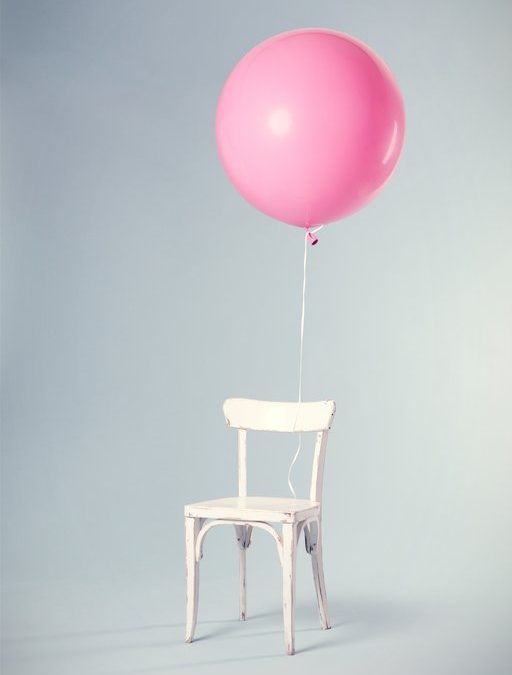 Empty chair with pink balloon adoption gender reveal